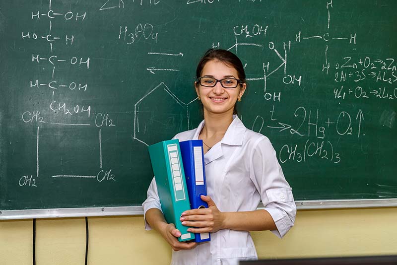 students standing proudly in front of chemistry equations