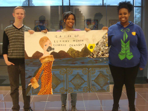 student standing with climate change poster